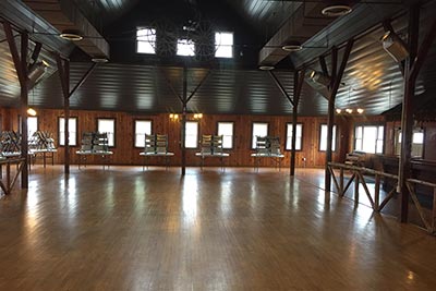 main open space, polished wooden floor, sunlight coming in through multiple windows